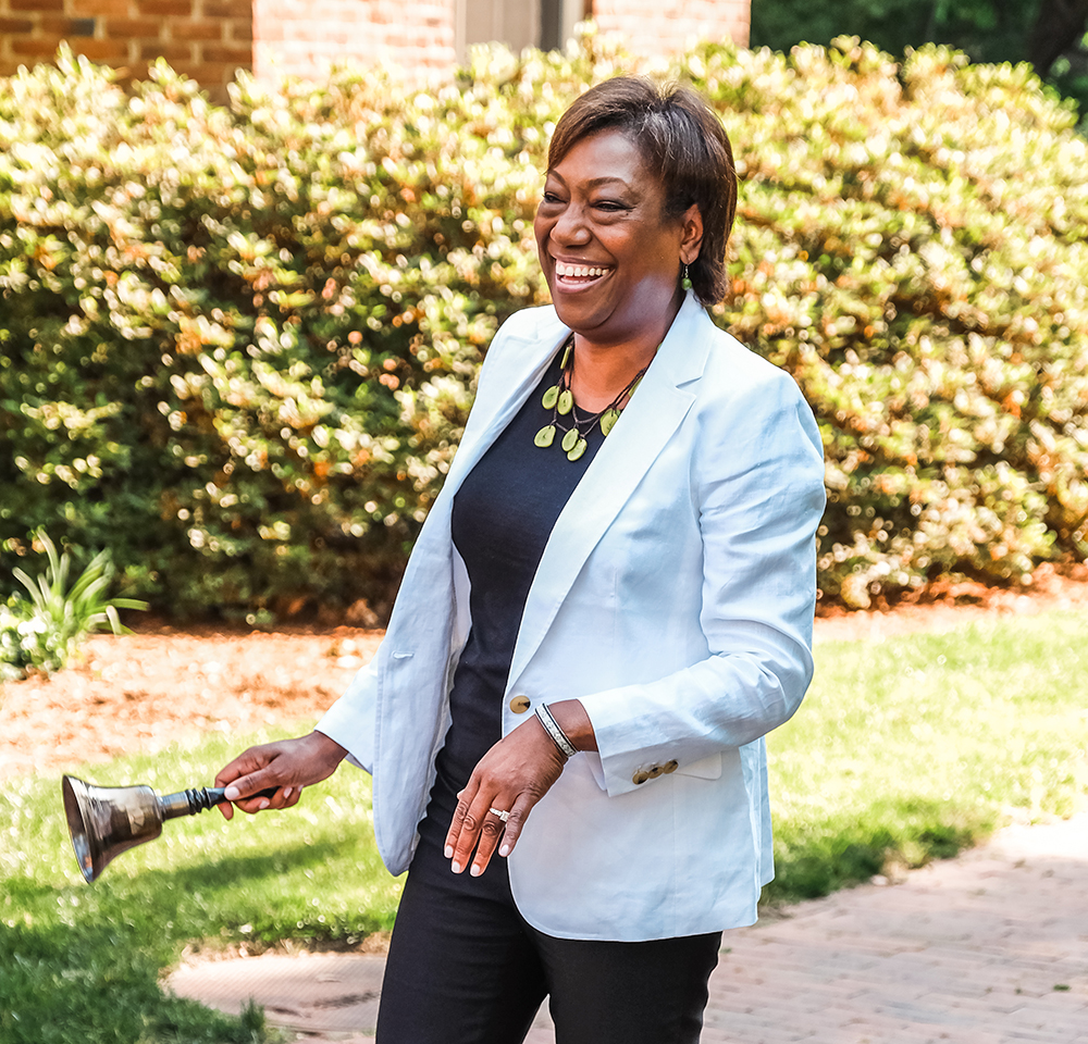 Patricia Parker smiles while ringing the Fellows’ Bell outside of Hyde Hall.